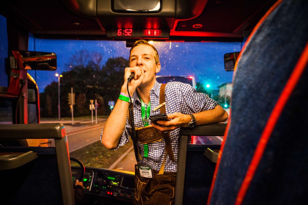 Oktoberfest ESN Group on a bus tour leader holding microphone at the front of the coach