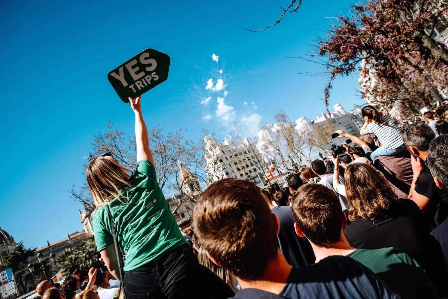 group of travellers one person holding a Yes Trips sign in the crowd