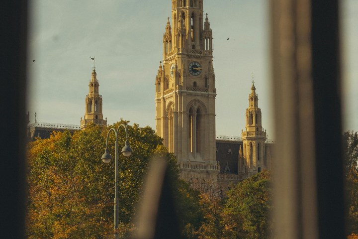 Tall, ornate building viewed through decorative metal fence.