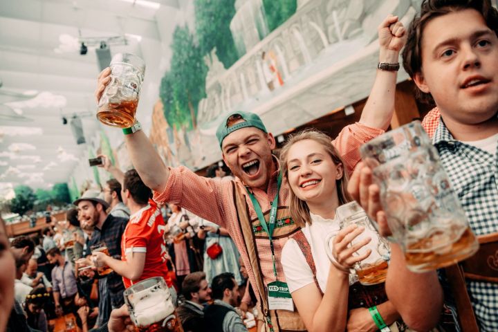 People celebrating with beer mugs at a festive event.