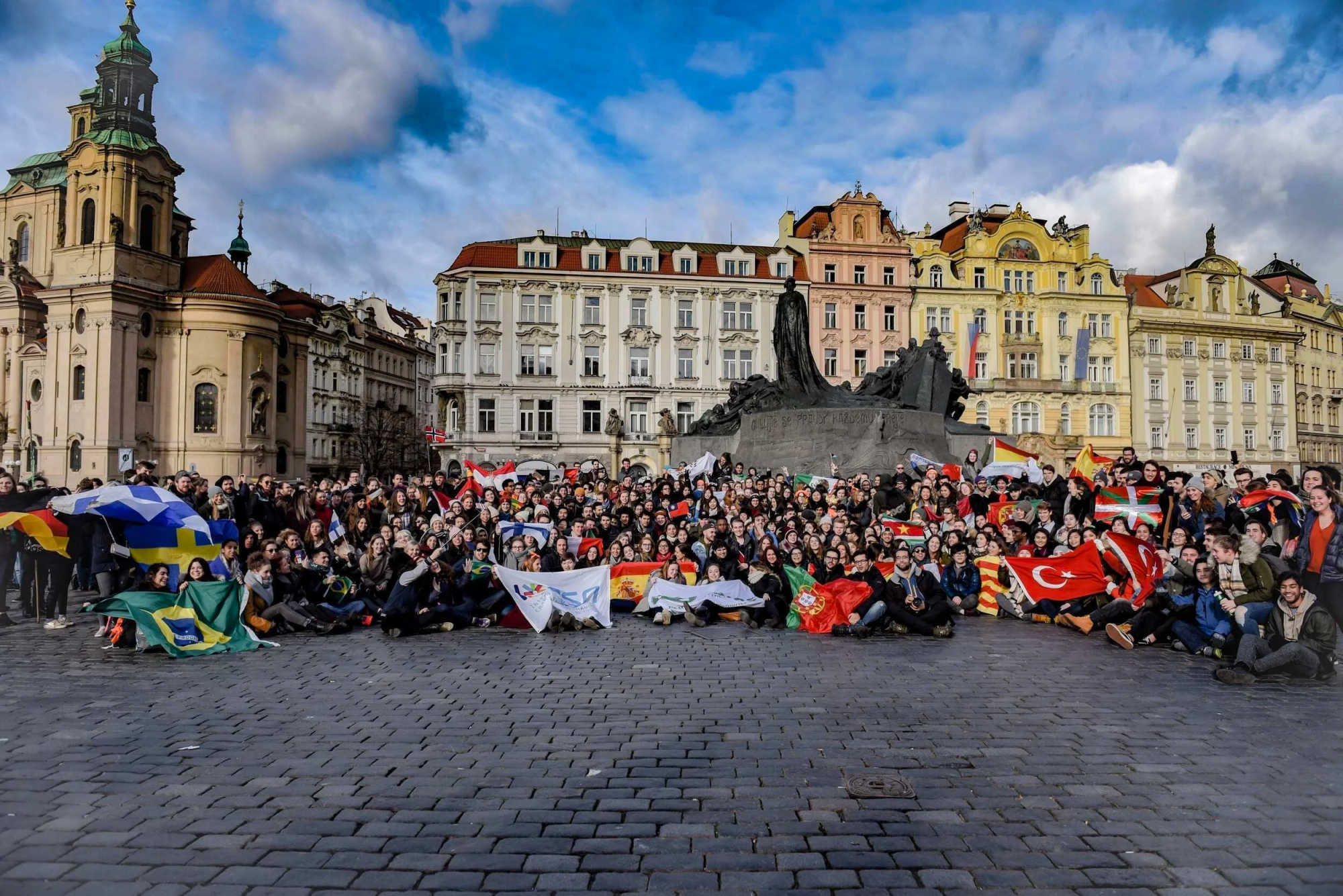Large group of people with flags in a European square.