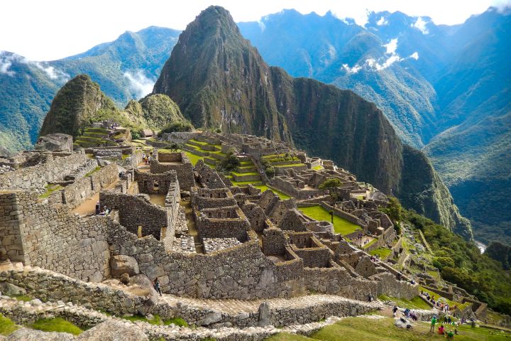 View of ancient stone ruins at Machu Picchu with mountains in the background.